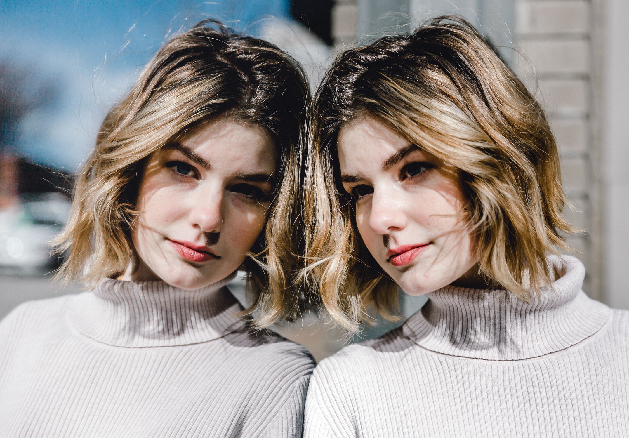 A woman in a turtleneck sweater is posing in front of a mirror, showcasing her personal branding.