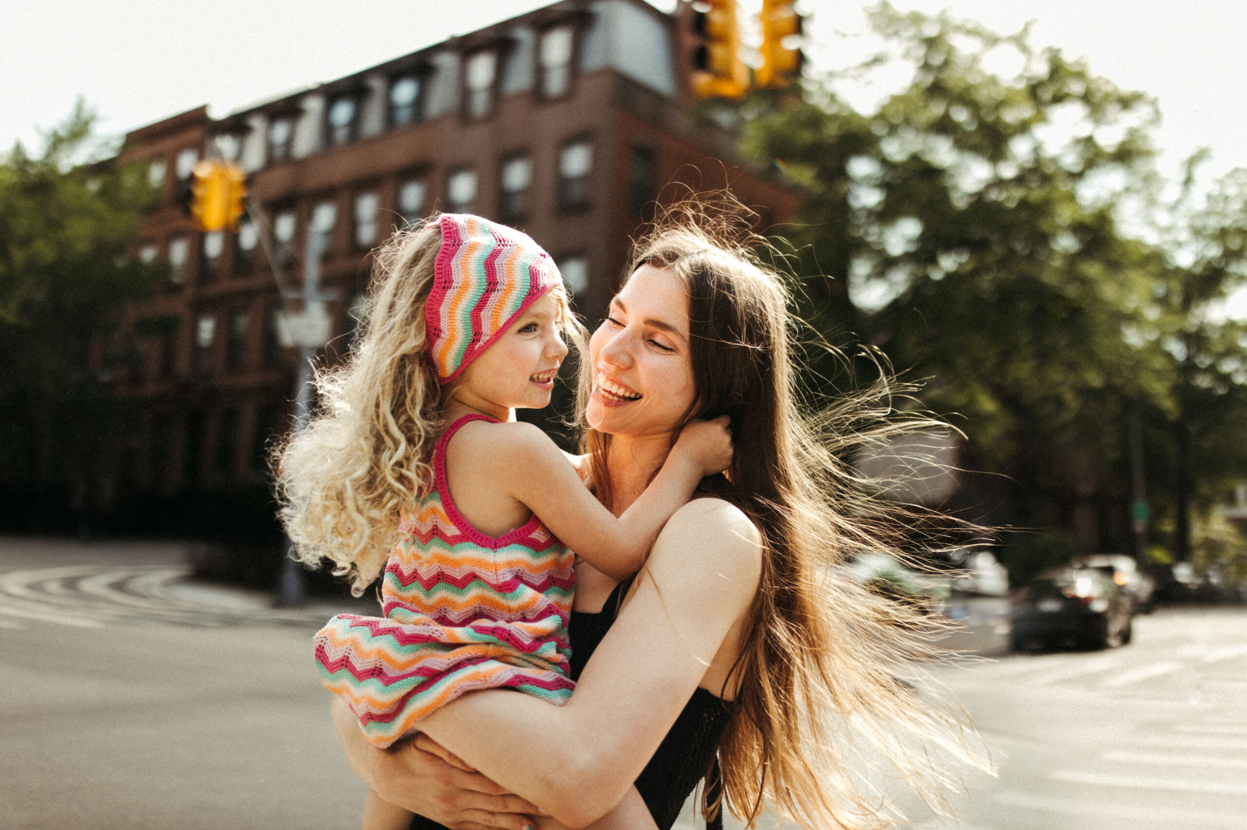 A woman is holding a little girl in Downtown Portland for a family photo session.